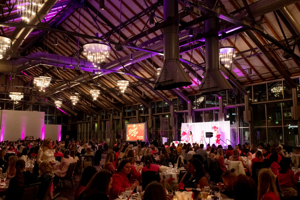 The Depot ballroom filled with tables of seated attendees at the Women's Leadership Panel.